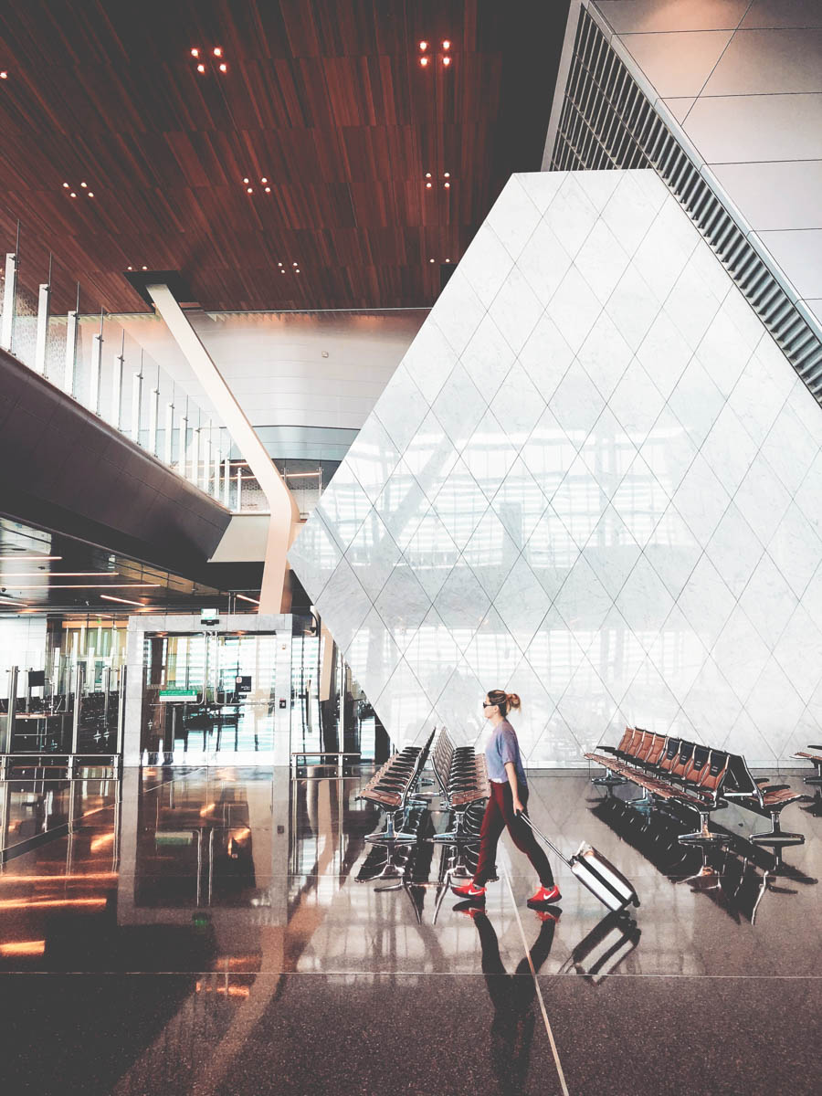 Woman walking at airport with a suitcase in her hand